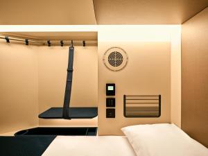 a room with a bed and a fan at Otherwander Soho Pod Hotel in London +46 photos