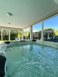 a swimming pool in a house with windows at Wellness Dorina in Siófok