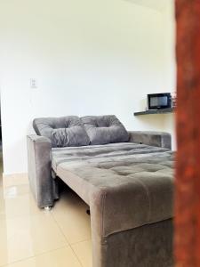 a grey couch sitting in a living room at Casa Quebec - Apartamentos in São Miguel do Gostoso