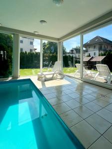 a swimming pool with two lawn chairs and a swimming pool at Wellness Dorina in Siófok