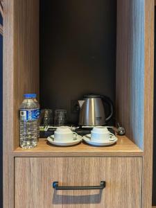 ein Schrank mit Tellern und einer Flasche Wasser in der Unterkunft Axis Hotel in Cimenli