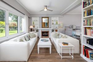 a living room with a white couch and a fireplace at Yi Garden Corfu in Corfu