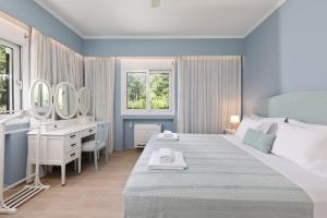 a bedroom with a large bed with a vanity and mirrors at Yi Garden Corfu in Corfu