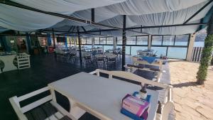 a white table and chairs under a tent with the ocean at Baraj Izvorul Muntelui Bibanu in Bicaz