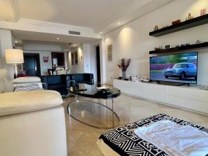 a living room with a couch and a tv at Beach front apartment Mar Azul in Estepona
