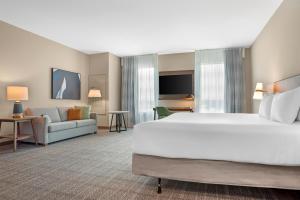 a hotel room with a large bed and a couch at Drury Inn & Suites Destin Miramar Beach in Destin +62 photos