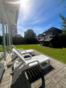 a group of white benches on a porch at Wellness apartman in Siófok