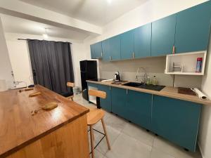 a kitchen with blue cabinets and a wooden table at Makeda in Chiconi