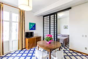 a living room with a table with a vase of flowers on it at Residence Villa Chiara in Loano