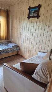 a bedroom with two beds and a tv on the wall at Domki Białogarda in Białogarda
