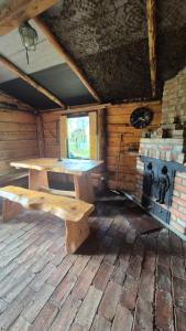a wooden bench in a room with a stove at Domki Białogarda in Białogarda