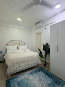 a white bedroom with a bed and a rug at Park View Stay in Male City