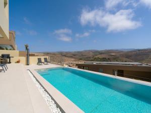 a swimming pool on the side of a building at Salobre Golf Villas Kaiman in Salobre