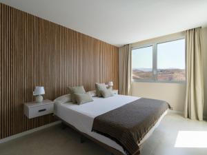a bedroom with a large bed and a large window at Salobre Golf Villas Kaiman in Salobre +107 photos