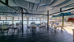 a pavilion with tables and chairs and a view of the water at Baraj Izvorul Muntelui Bibanu in Bicaz