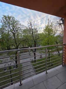 ein Balkon mit Blick auf einen Park mit Bäumen in der Unterkunft SaDa Centar in Apatin