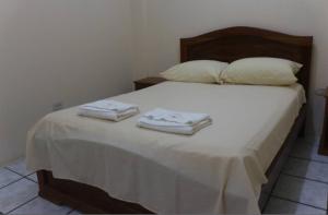a bedroom with a bed with towels on it at Hostal El Bosque in Pedernales