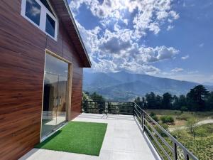 a balcony with a view of the mountains at Seraahi Hills Resort in Bhadarwāh