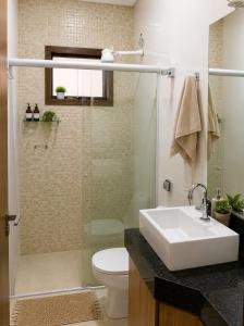 a bathroom with a sink and a toilet and a shower at Pousada Economia in Paracatu