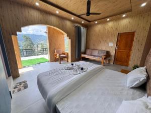 a bedroom with a large bed and a large window at Seraahi Hills Resort in Bhadarwāh