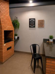 a black chair and a clock on a wall at Pousada Economia in Paracatu +3 photos