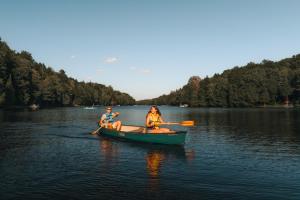 two people in a canoe on a lake at Fiddler Lake 72 with Private spa, pool table & Pool in Mille-Isles