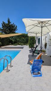 a pair of chairs and an umbrella next to a swimming pool at Masseria Mustazzo in Siponto
