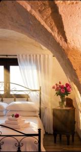 a bedroom with a bed and a vase of flowers on a table at Casa vacanza La Dimora in San Pancrazio Salentino