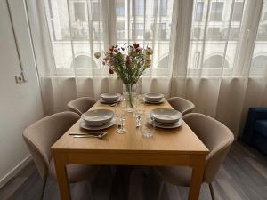 a table with plates and glasses and a vase of flowers at Moderne Studio Wohnung in Stuttgart-Zentrum in Stuttgart