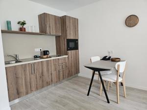 a kitchen with a table and two chairs and a sink at DOMITYS - Les Passementiers in Villars