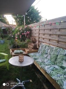 a patio with a couch and a table in a yard at Aéroport chambre , au calme in Bouguenais