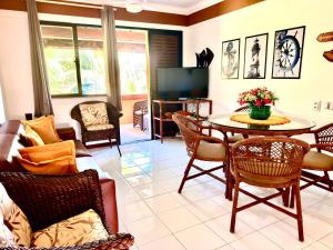 a living room with a table and chairs at Flat 3 Quartos Pé na Areia, Piscina e Mar, Summer House Genipabu, Guarajuba in Guarajuba