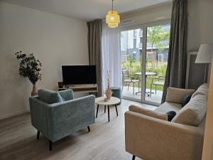 a living room with two chairs and a television at DOMITYS - Les Passementiers in Villars +7 photos