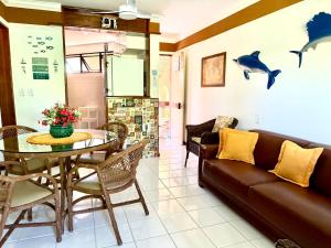 a living room with a couch and a table at Flat 3 Quartos Pé na Areia, Piscina e Mar, Summer House Genipabu, Guarajuba in Guarajuba