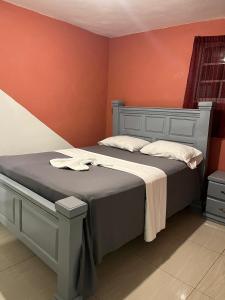 a bedroom with two beds and a red wall at BaYO HOTEL in Vaudreuil