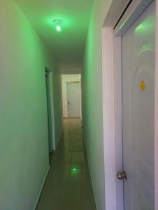 an empty hallway with green walls and a white door at BaYO HOTEL in Vaudreuil