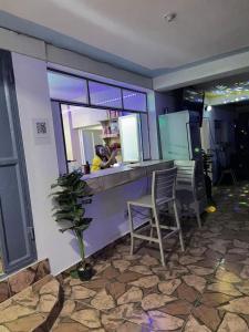 a restaurant with a bar with two chairs and a mirror at BaYO HOTEL in Vaudreuil