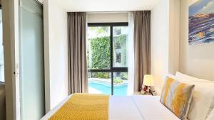 a bedroom with a bed and a window at Stylish Diamond Condo Bangtao with Pool View in Bang Tao Beach +48 photos