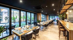 a row of tables in a restaurant with windows at Stylish Diamond Condo Bangtao with Pool View in Bang Tao Beach