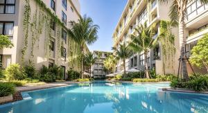 a swimming pool in the courtyard of a building at Stylish Diamond Condo Bangtao with Pool View in Bang Tao Beach