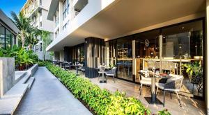 a restaurant with tables and chairs in a building at Stylish Diamond Condo Bangtao with Pool View in Bang Tao Beach