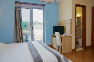 a bedroom with a bed and a desk with a television at Hotel Blue Moon in Ulcinj