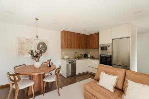 a kitchen and living room with a couch and a table at Serpa Pinto Village - Private Pool - by FERO in Cinfães