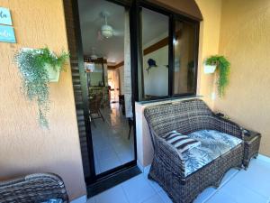 a wicker chair sitting on the outside of a house at Flat 3 Quartos Pé na Areia, Piscina e Mar, Summer House Genipabu, Guarajuba in Guarajuba +26 photos