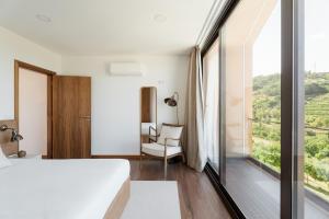 a bedroom with a bed and a large window at Serpa Pinto Village - Private Pool - by FERO in Cinfães +18 photos