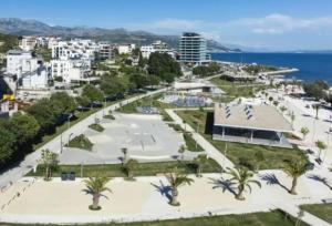 a city with a park with palm trees and the ocean at Adela Apartments - Beach Žnjan Split in Split