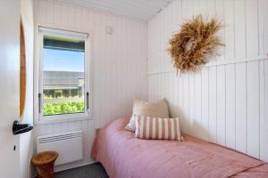 a small bedroom with a bed and a window at FY402-Asperup-Eskelundsvaenget-9 in Voldby
