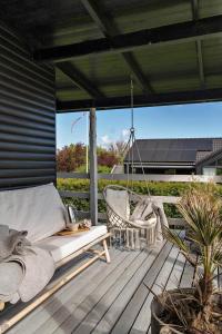 a porch with a hammock and a swing at FY402-Asperup-Eskelundsvaenget-9 in Voldby