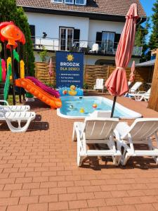 Atlantic aqua resort في خووبي: مسبح مزود بمنزلق مائي وكرسيين ومظلة