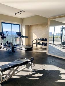 a gym with cardio machines and a large window at Apartamento Moderno z 10-Jacuzzi-Lavandería-AC-Gym-GuatemalaCity in Lo de Contreras
